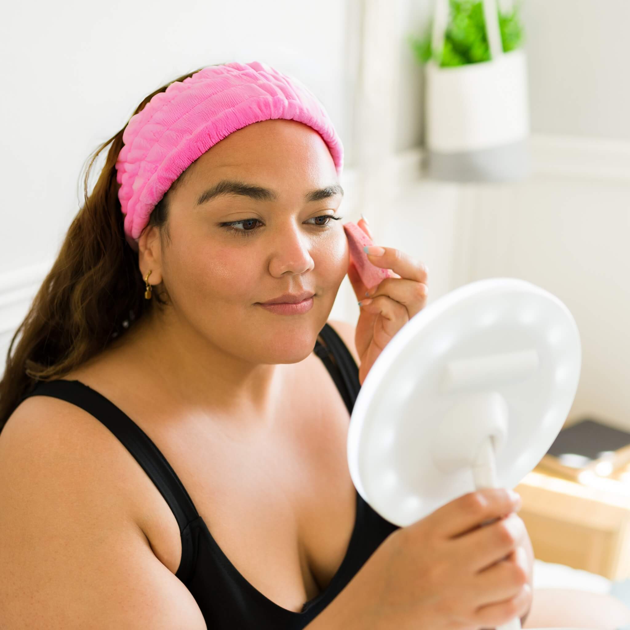 girl in bathroom looking at her skin in a mirror