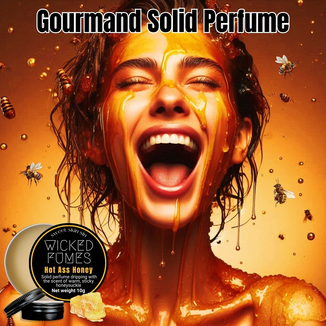 woman dripping with honey with pure joy on her face. the title says gourmand solid perfume and there is a tin of hot ass honey 